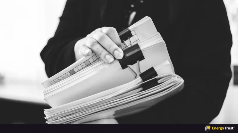 man holding bundled papers