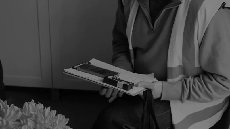 Black and White Photo of a Domestic Energy Assessor (DEA) on site assessing a home to create an energy performance certificate (EPC)